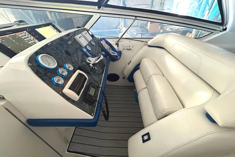 Slide: The Image of 2005 Fountain 48 Express Cruiser helm with white seating and modern dashboard controls. - 19