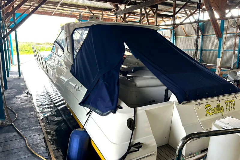 Slide: The Image of 2005 Fountain 48 Express Cruiser docked under a covered structure. - 4