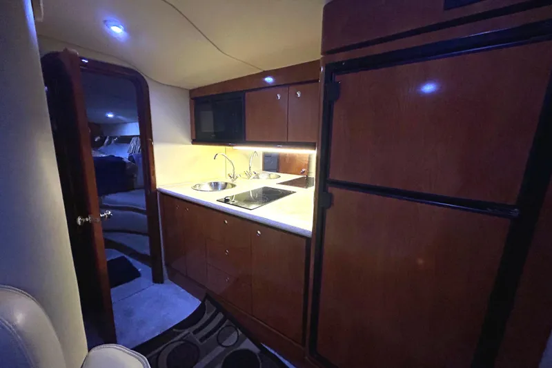 Slide: The Image of 2005 Fountain 48 Express Cruiser interior kitchen with wood cabinetry and modern appliances. - 9