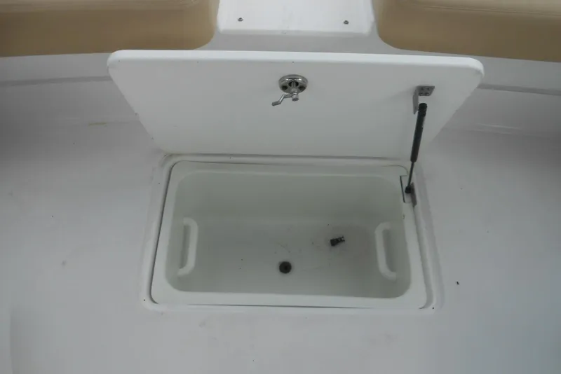 Slide: The Image of Open storage compartment on 2015 Cobalt 296 boat, featuring a white interior. - 11