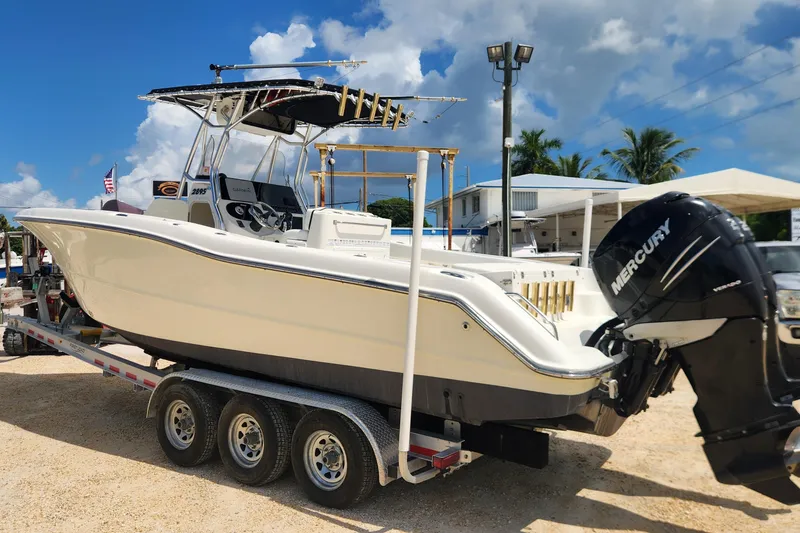 The Image of 2007 Triton 2895 CC boat on trailer with Mercury outboard motor, parked outdoors. - 1