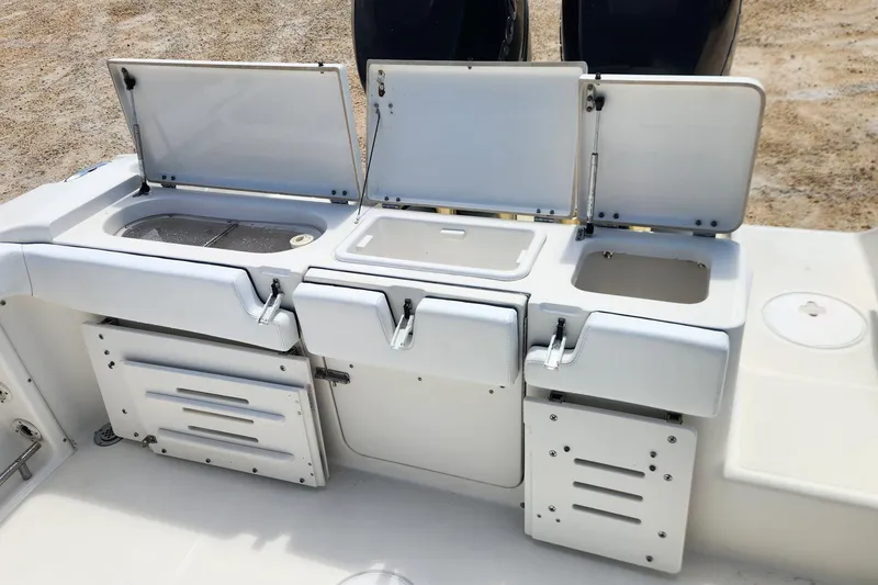 Slide: The Image of 2007 Triton 2895 CC boat with open storage compartments and livewell on deck. - 13