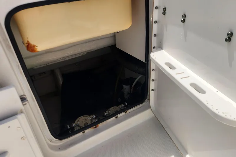 Slide: The Image of 2007 Triton 2895 CC boat storage compartment with visible interior components. - 14