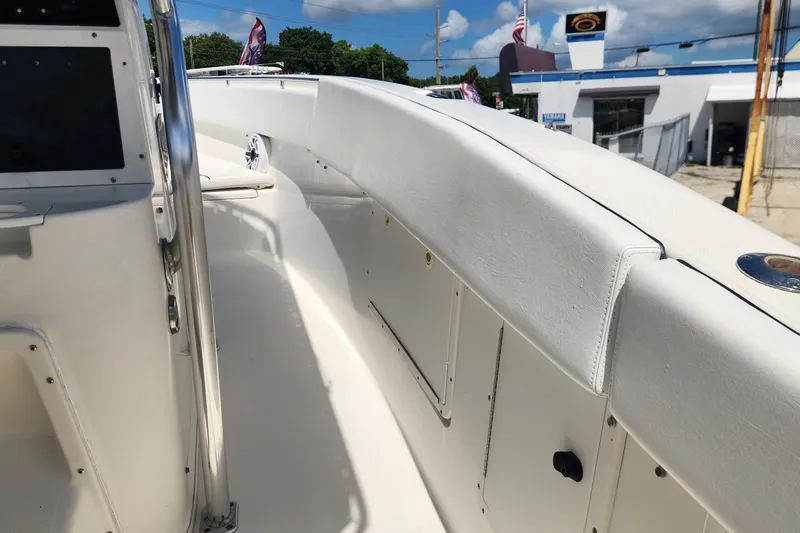 Slide: The Image of 2007 Triton 2895 CC boat interior with white seating and storage compartments. - 17