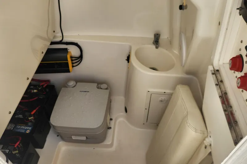Slide: The Image of 2007 Triton 2895 CC boat interior with sink, portable toilet, and battery compartment. - 20
