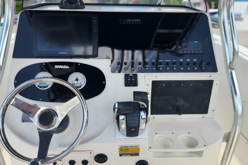 Slide: The Image of Control panel of a 2007 Triton 2895 CC boat with steering wheel and gauges. - 8