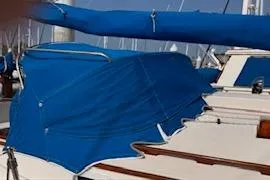 Slide: The Image of 1983 Nonsuch 36 sailboat with blue canvas cover in marina. - 23