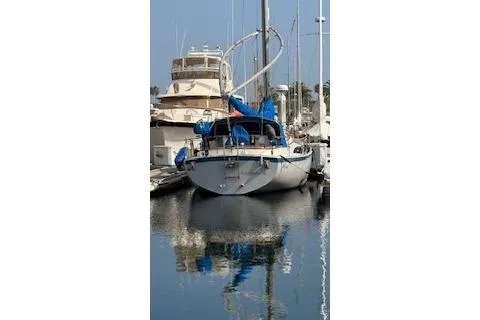Slide: The Image of 1983 Nonsuch 36 sailboat docked in a marina, reflecting on calm water. - 25