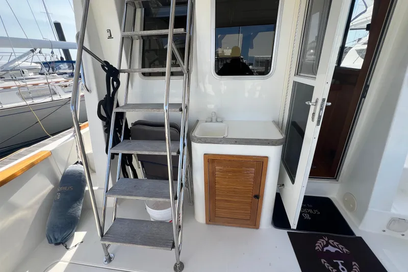 Slide: The Image of 2005 Sabre Flybridge yacht with ladder, sink, and wooden cabinet on deck. - 13