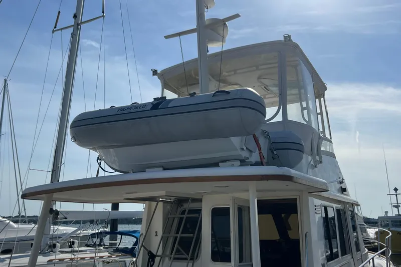 Slide: The Image of 2005 Sabre Flybridge yacht with dinghy on top, docked at marina under clear sky. - 15