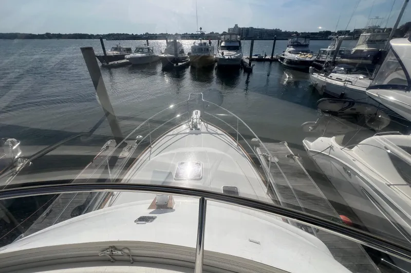 Slide: The Image of 2005 Sabre Flybridge yacht docked at marina, surrounded by other boats on a sunny day. - 17