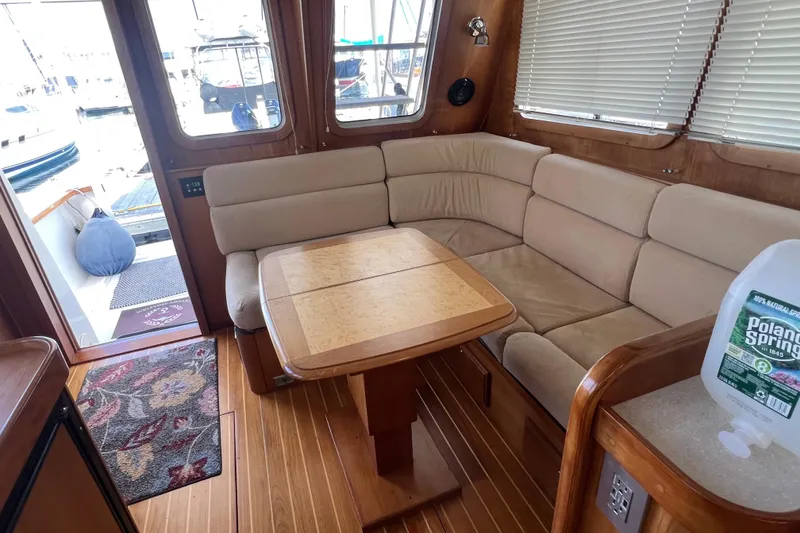 Slide: The Image of Interior of 2005 Sabre Flybridge yacht with beige seating and wooden table. - 20