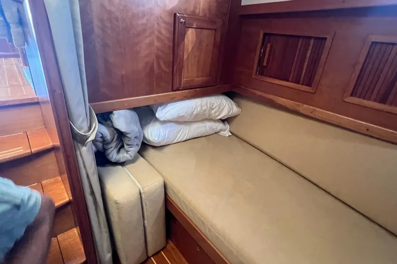 Slide: The Image of 2005 Sabre Flybridge interior with cozy wooden cabin and cushioned seating area. - 23