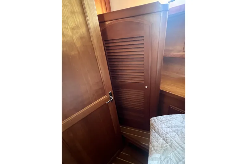 Slide: The Image of 2005 Sabre Flybridge interior with wooden closet and bed corner. - 25