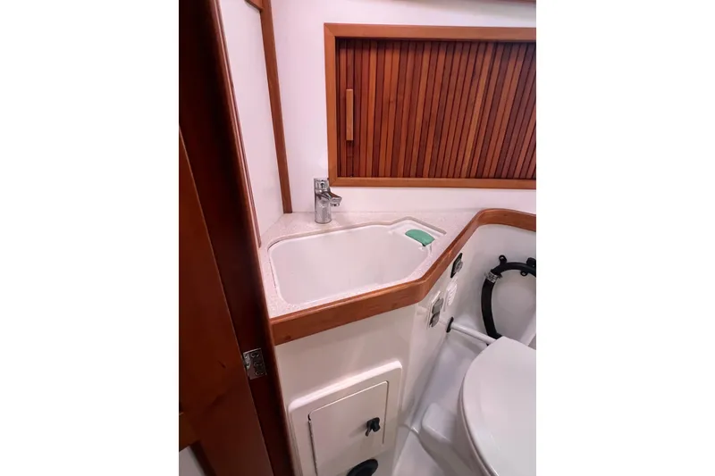 Slide: The Image of 2005 Sabre Flybridge bathroom with sink, wooden accents, and modern fixtures. - 26