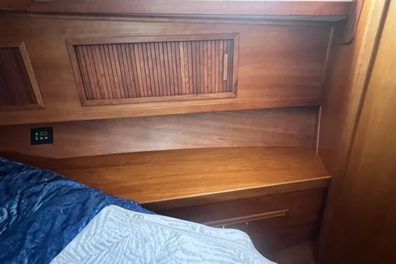 Slide: The Image of 2005 Sabre Flybridge interior with wooden cabinetry and bed corner. - 29