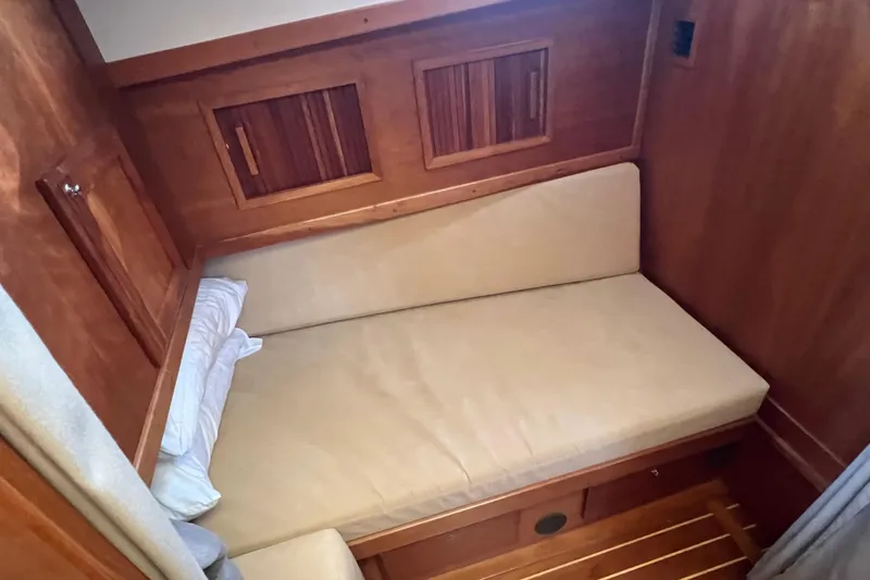 Slide: The Image of 2005 Sabre Flybridge cabin interior with wooden finish and cozy bed. - 33