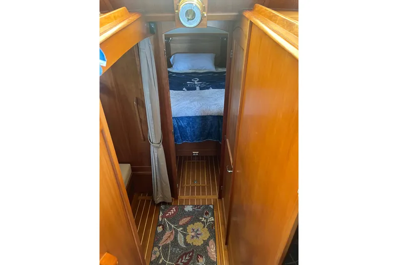 Slide: The Image of 2005 Sabre Flybridge interior with wooden finish, cozy bed, and nautical decor. - 34