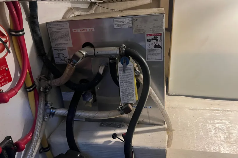 Slide: The Image of Engine room of 2005 Sabre Flybridge with visible piping and warning labels. - 35