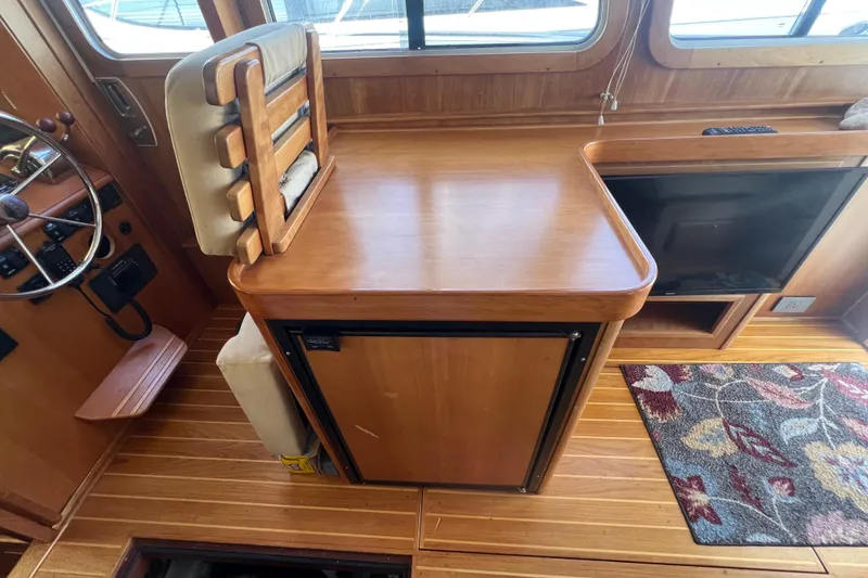 Slide: The Image of 2005 Sabre Flybridge interior with wooden helm, seating, and patterned rug. - 40