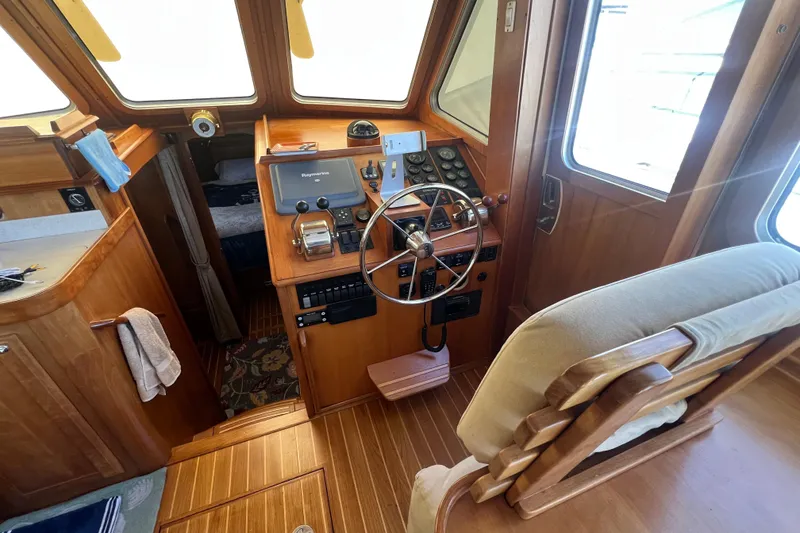 Slide: The Image of 2005 Sabre Flybridge helm with wooden interior, steering wheel, and navigation equipment. - 47