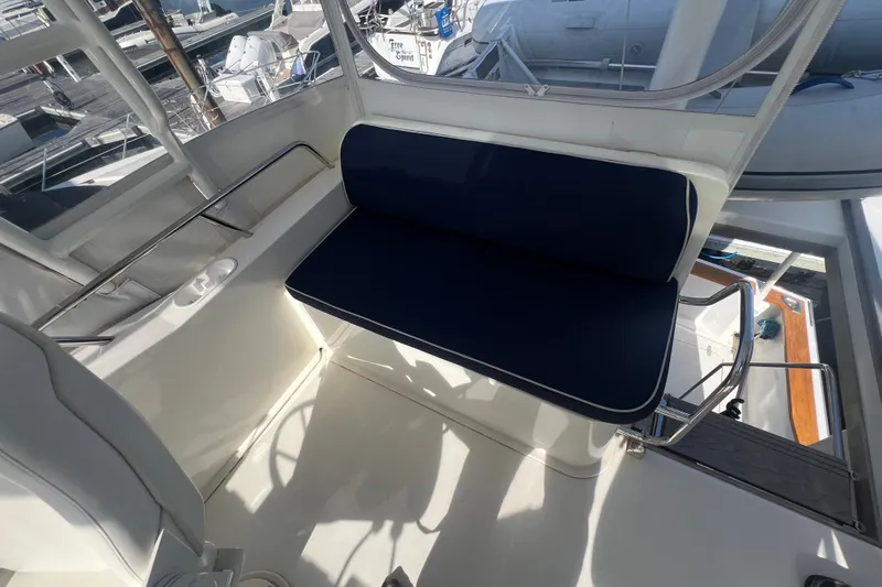 Slide: The Image of 2005 Sabre Flybridge interior with blue cushioned seating and marina view. - 51