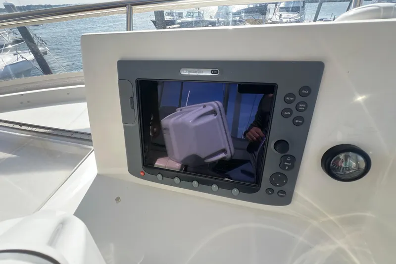 Slide: The Image of 2005 Sabre Flybridge control panel with navigation display and buttons, overlooking marina. - 56