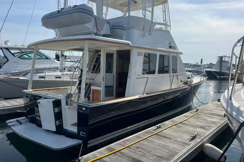 Slide: The Image of 2005 Sabre Flybridge yacht docked at marina, featuring sleek design and spacious deck. - 8