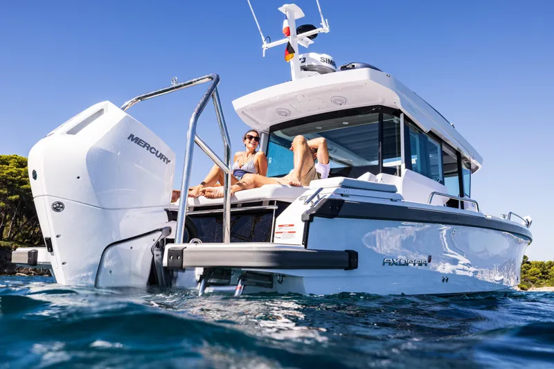 Slide: The Image of 2026 Axopar 29 XC boat with Mercury engine, people relaxing on deck, sunny day. - 10