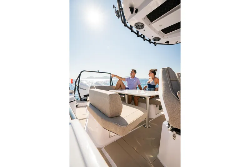 Slide: The Image of Couple enjoying sunny day on 2026 Axopar 29 XC boat, seated comfortably. - 13