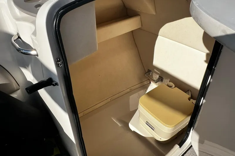 Slide: The Image of 2003 Sea Ray 220 Sundeck interior with compact marine toilet. - 11