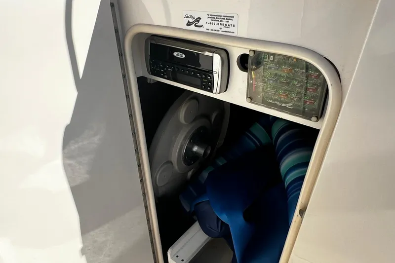 Slide: The Image of Storage compartment in a 2003 Sea Ray 220 Sundeck boat with stereo and fuse panel. - 13