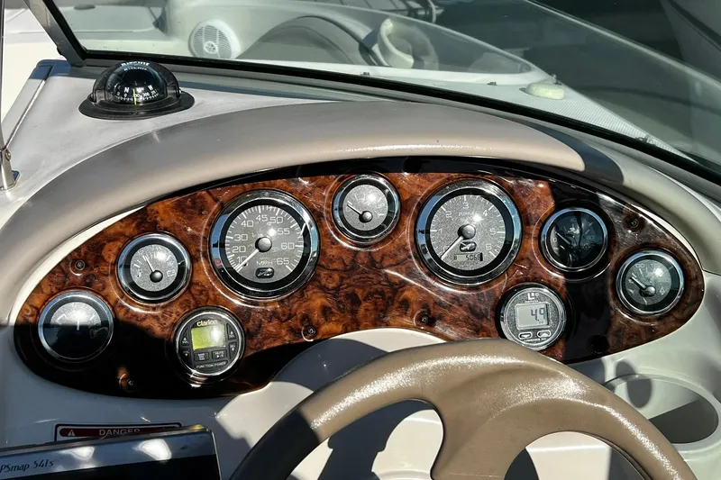 Slide: The Image of Dashboard of 2003 Sea Ray 220 Sundeck with wood grain finish and gauges. - 17