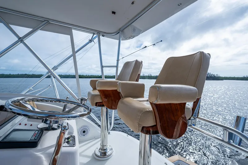 Slide: The Image of 2008 Ocean Yachts 37 Billfish helm with leather seats and steering wheel, overlooking serene waters. - 16