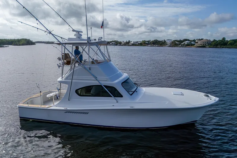 Slide: The Image of 2008 Ocean Yachts 37 Billfish cruising on a calm river under a cloudy sky. - 2