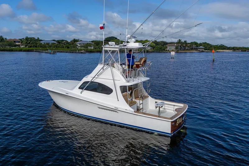 Slide: The Image of 2008 Ocean Yachts 37 Billfish boat on calm water, with clear skies and lush shoreline. - 3