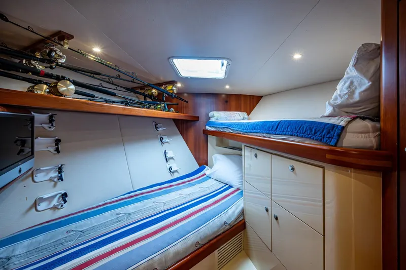 Slide: The Image of Cozy cabin interior of 2008 Ocean Yachts 37 Billfish with fishing rods and bunk beds. - 38