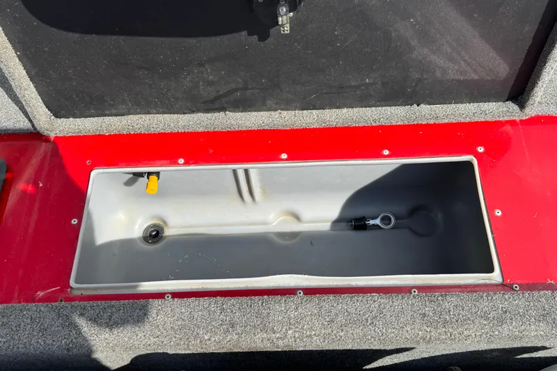 Slide: The Image of 2013 Alumacraft Pro 185 boat storage compartment with red trim and gray interior. - 10