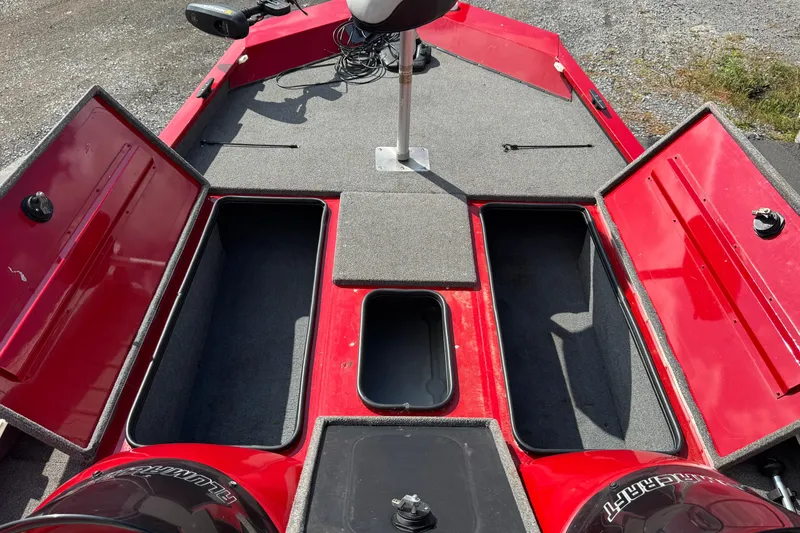 Slide: The Image of 2013 Alumacraft Pro 185 boat interior with open storage compartments, red and gray design. - 11