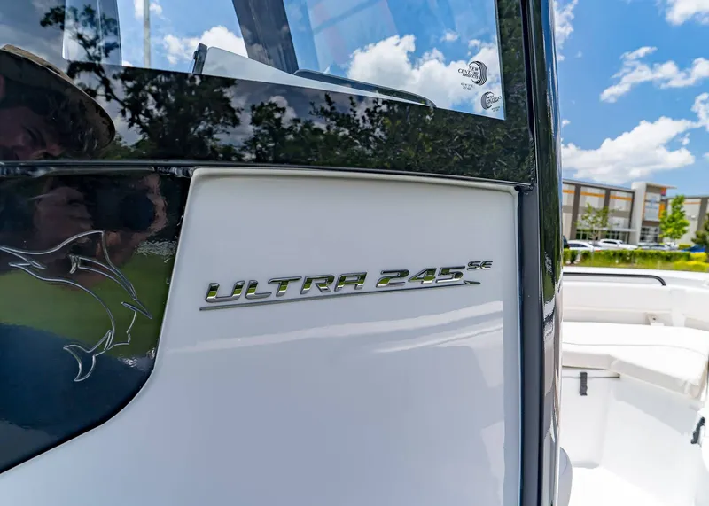 Slide: The Image of 2026 Sea Hunt Ultra 245 SE boat exterior with logo, sunny day background. - 12