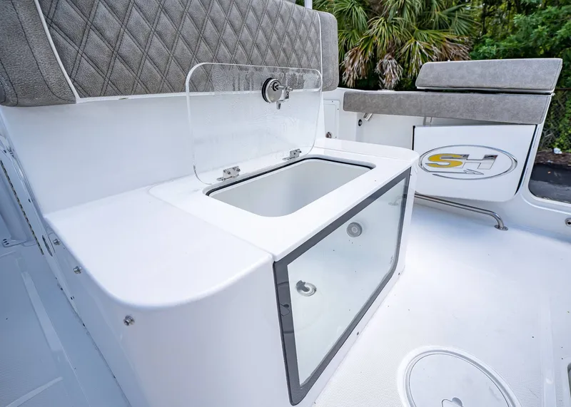 Slide: The Image of 2026 Sea Hunt Ultra 305 SE boat with open storage compartment and cushioned seating. - 16