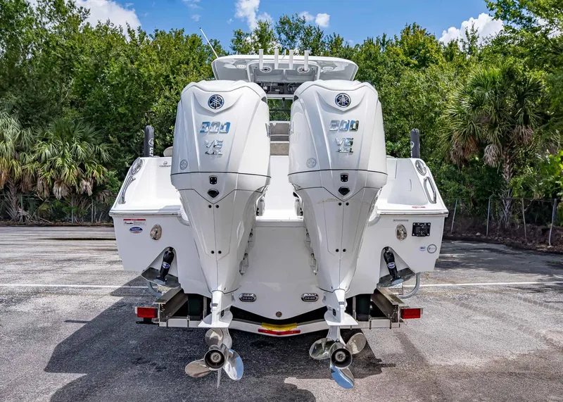 Slide: The Image of 2026 Sea Hunt Ultra 305 SE boat with dual outboard engines, parked outdoors. - 5