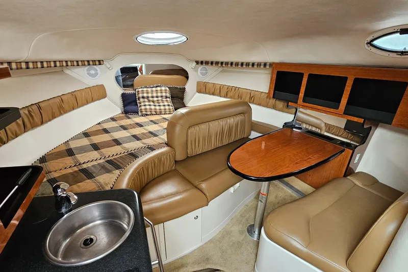 Slide: The Image of Interior of 2004 Monterey 282 Cruiser with cozy seating, table, and kitchenette. - 13