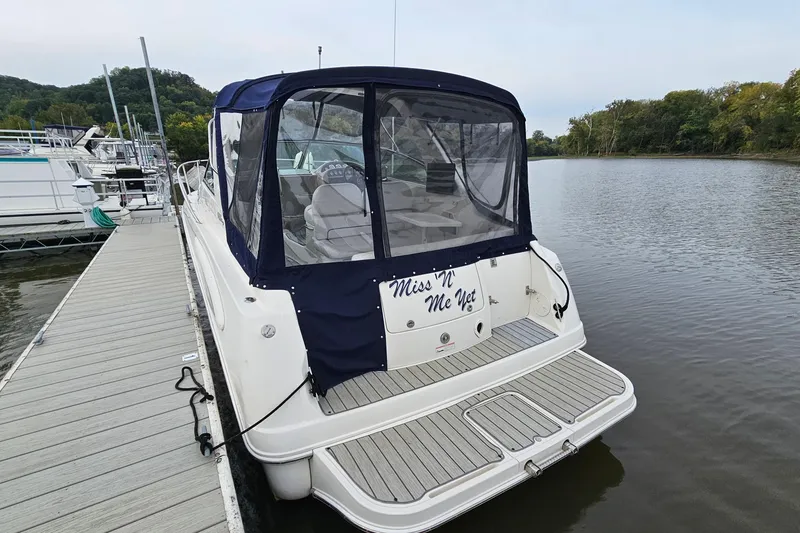 Slide: The Image of 2004 Monterey 282 Cruiser docked by a serene river with a covered cockpit. - 4