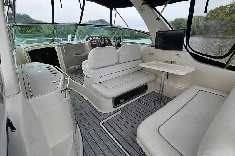 Slide: The Image of 2004 Monterey 282 Cruiser interior with seating, table, and helm, overlooking water. - 5