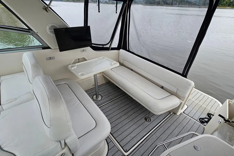 Slide: The Image of 2004 Monterey 282 Cruiser interior with white seating, table, and lake view. - 6