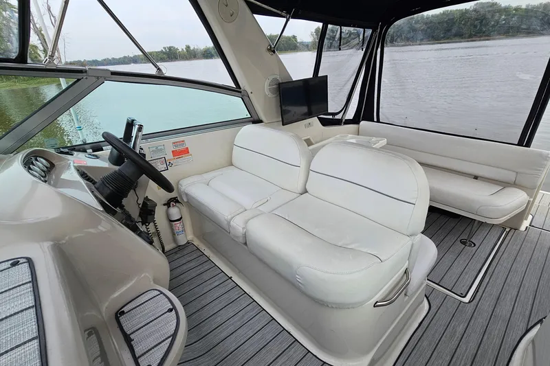 Slide: The Image of 2004 Monterey 282 Cruiser interior with white seating, steering wheel, and river view. - 8