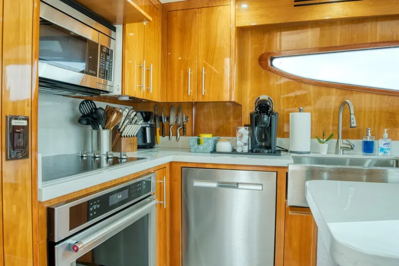 Slide: The Image of Luxurious kitchen in 2007 Hatteras 80 Enclosed Bridge yacht with modern appliances and wooden cabinetry. - 18