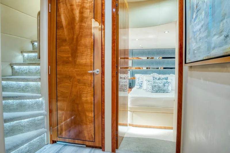 Slide: The Image of Interior of 2007 Hatteras 80 Enclosed Bridge yacht, featuring a cozy bedroom and elegant wooden door. - 23