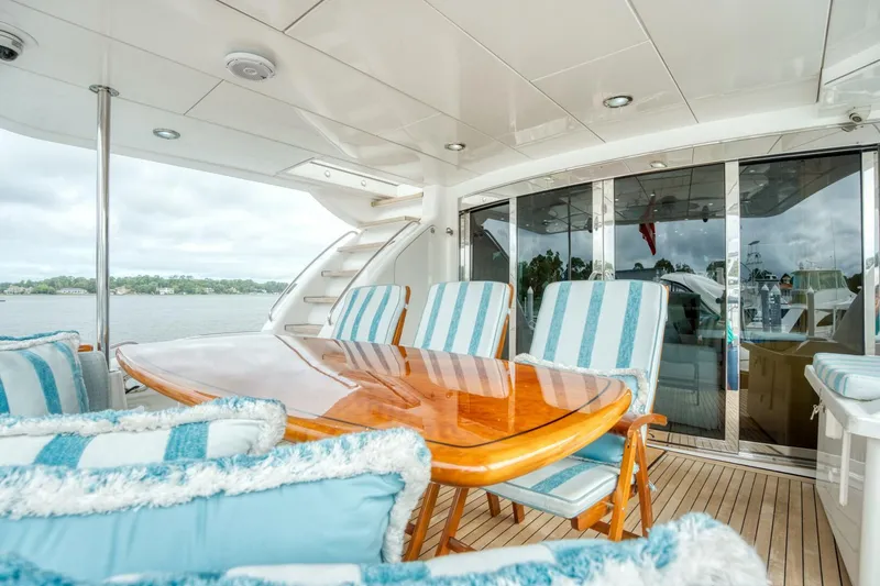 Slide: The Image of Luxurious 2007 Hatteras 80 Enclosed Bridge yacht with elegant outdoor seating and dining area. - 3